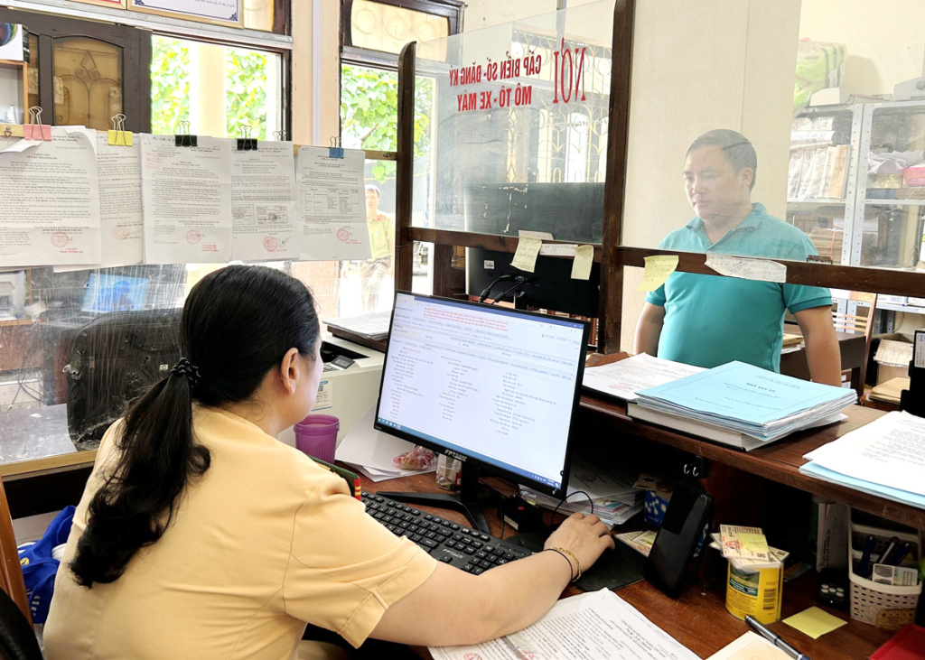 Công an huyện Yên Minh làm thủ tục đăng ký, cấp biển số ô tô cho chủ phương tiện.