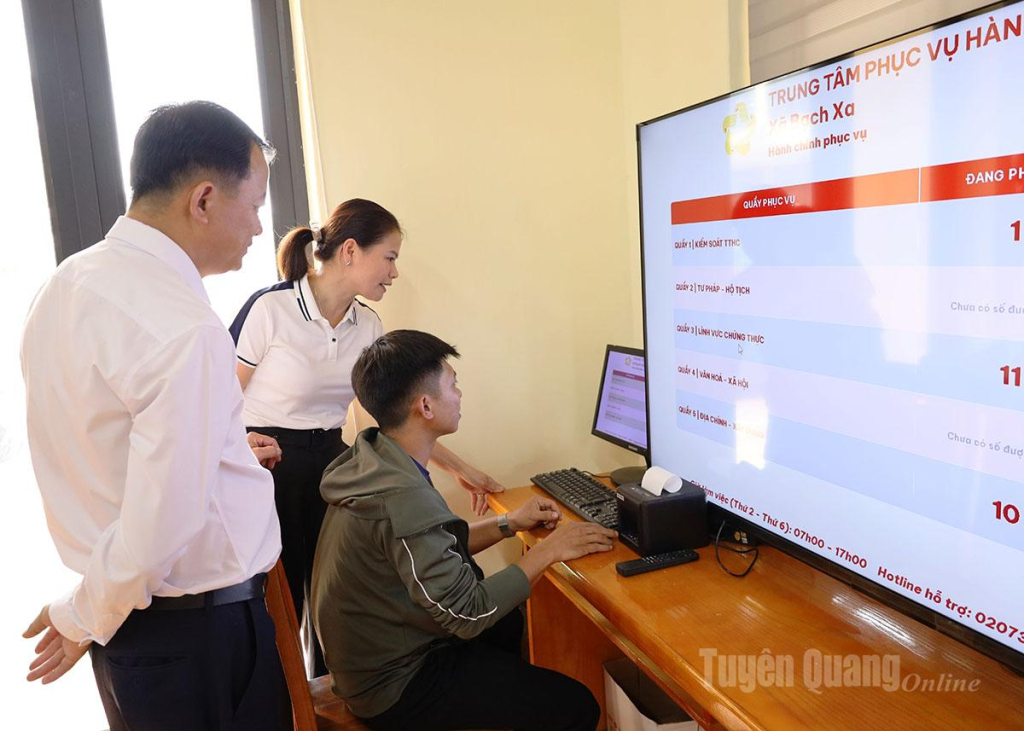Cán bộ Trung tâm Phục vụ hành chính công xã Bạch Xa hướng dẫn người dân lấy số thứ tự tự động khi đến giải quyết thủ tục hành chính. 