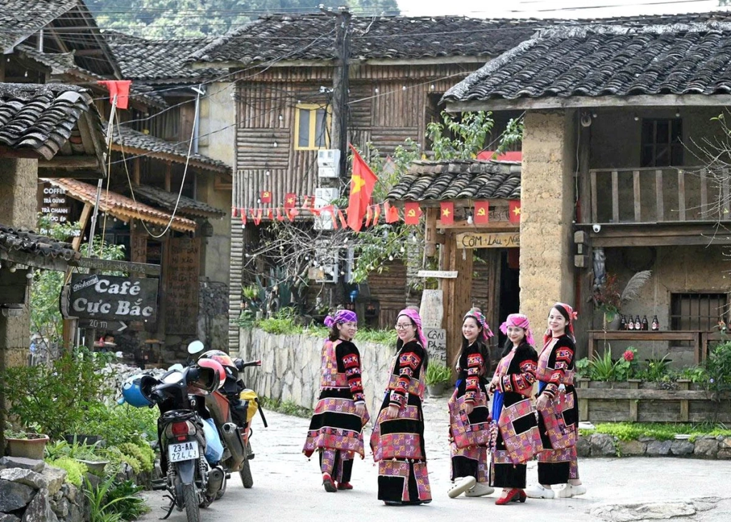 Tourists enjoy wearing traditional Lo Lo ethnic costumes.