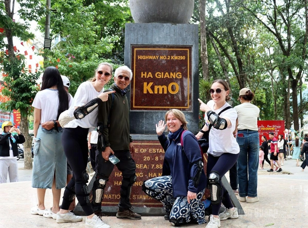 Foreign visitors take photos at the Km 0 Ha Giang symbol.