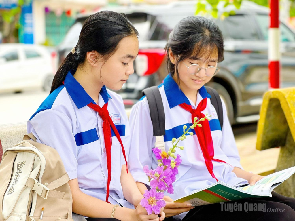 Có những bạn học sinh tranh thủ ôn lại bài vừa được học trên lớp dưới tán Bằng lăng.