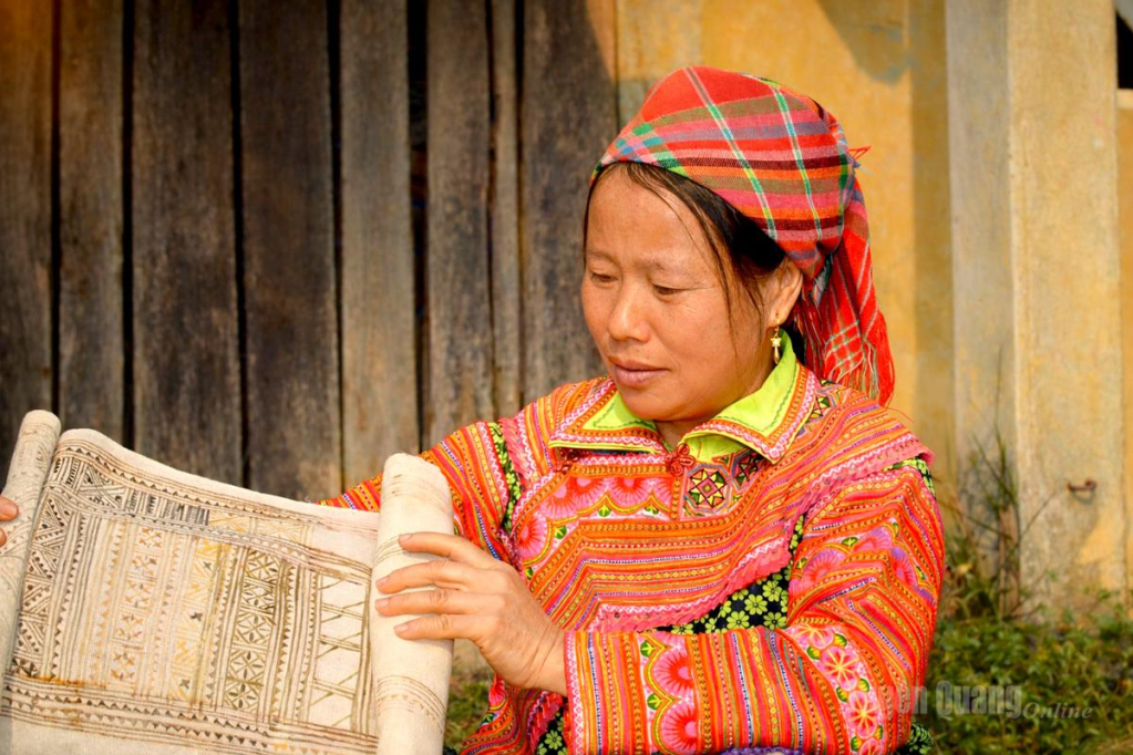 Chị Chính kiểm tra tấm vải lanh sau công đoạn vẽ sáp ong.