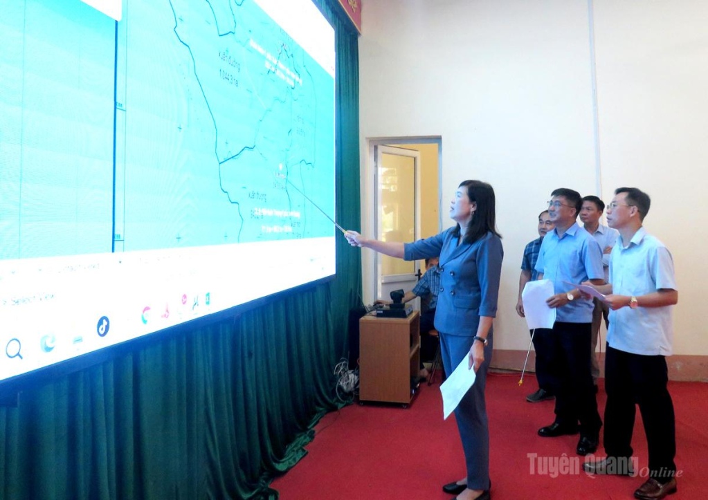 Đồng chí Phạm Thị Minh Xuân kiểm tra bản đồ phương án sắp xếp thôn của xã Liên Hiệp.