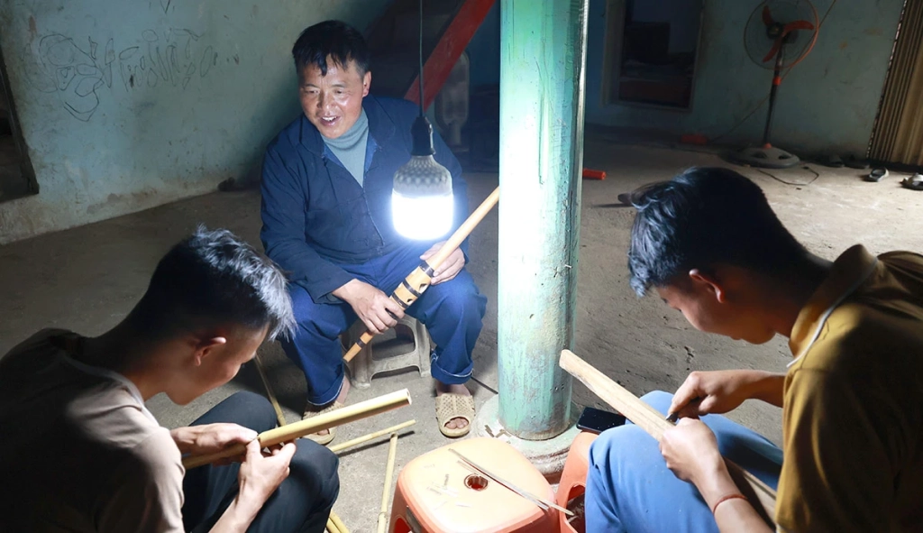 Để tiếng khèn không chỉ vang trong hiện tại mà còn được truyền lại cho mai sau, việc đào tạo thế hệ kế cận đang được địa phương đặc biệt chú trọng. Trong ảnh, trưởng thôn Mua Mí Lử đang hướng dẫn hai thanh niên trẻ những công đoạn làm nên 1 chiếc khèn.