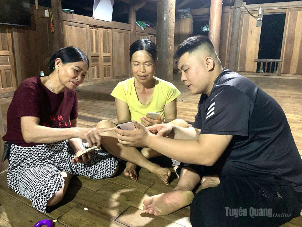 Anh Hoàng Ngọc Oánh, Trưởng ban công tác Mặt trận thôn Xuân Hòa, xã Khuôn Lùng hướng dẫn bà con thực hiện thủ tục hành chính trên điện thoại thông minh.