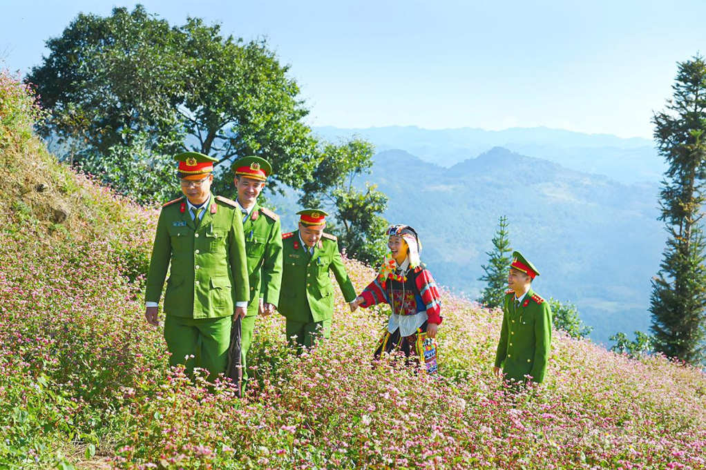 Sự gần gũi, đồng hành của sắc phục xanh cùng đồng bào dân tộc Lô Lô trong trang phục truyền thống trên những triền hoa tam giác mạch rực rỡ.