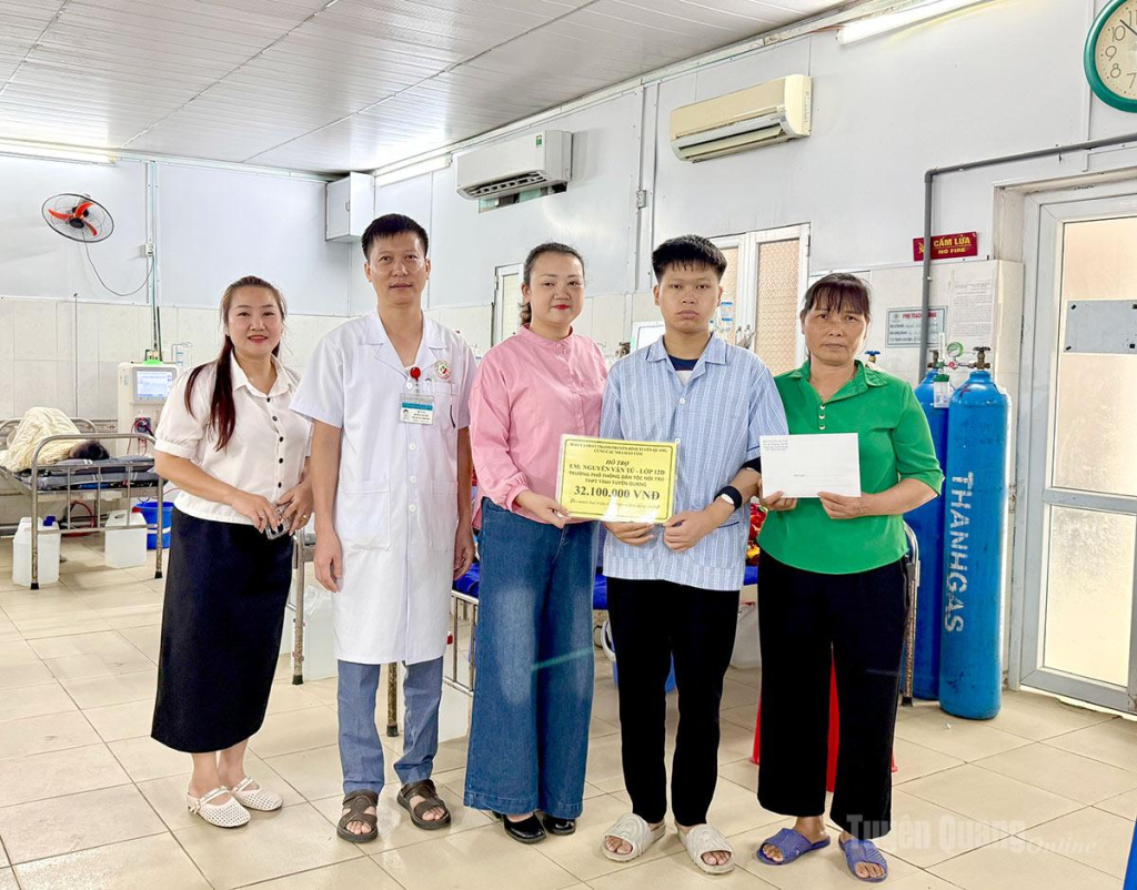 Báo và phát thanh, truyền hình Tuyên Quang cùng cán bộ Bệnh viện Đa khoa tỉnh trao tiền hỗ trợ cho em Nguyễn Văn Tú, lớp 12D, Trường Phổ thông Dân tộc nội trú THPT tỉnh Tuyên Quang.