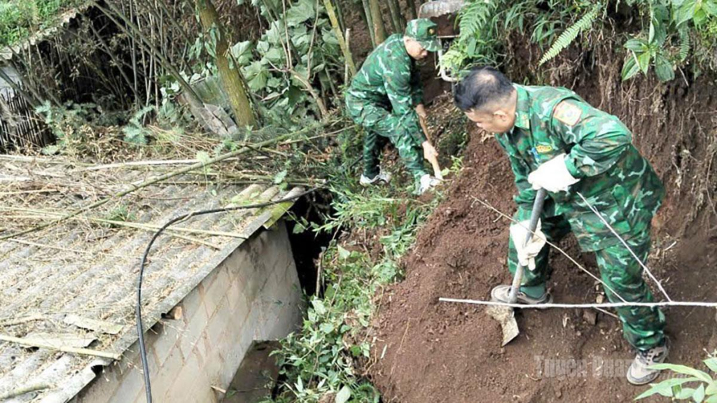 Các lực lượng giúp người dân dọn dẹp đất đá sau sạt lở tại thôn Lùng Thúng.