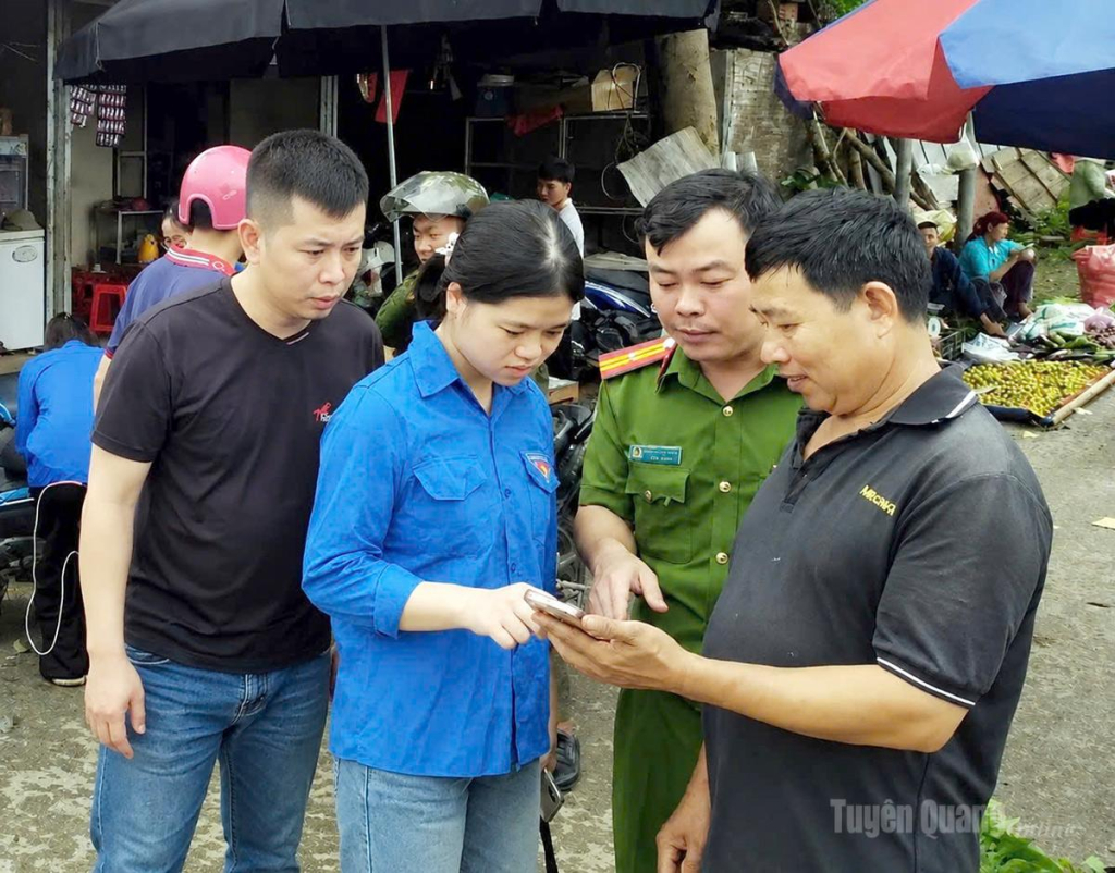 Tổ công nghệ số cộng đồng xã Tát Ngà hướng dẫn người dân đăng ký tài khoản dịch vụ công trực tuyến tại buổi họp chợ phiên Nậm Ban.