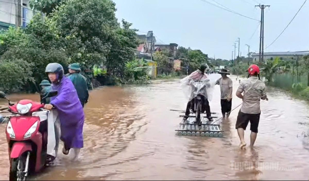 Các lực lượng chức năng hỗ trợ người dân di chuyển qua đoạn ngập nước.