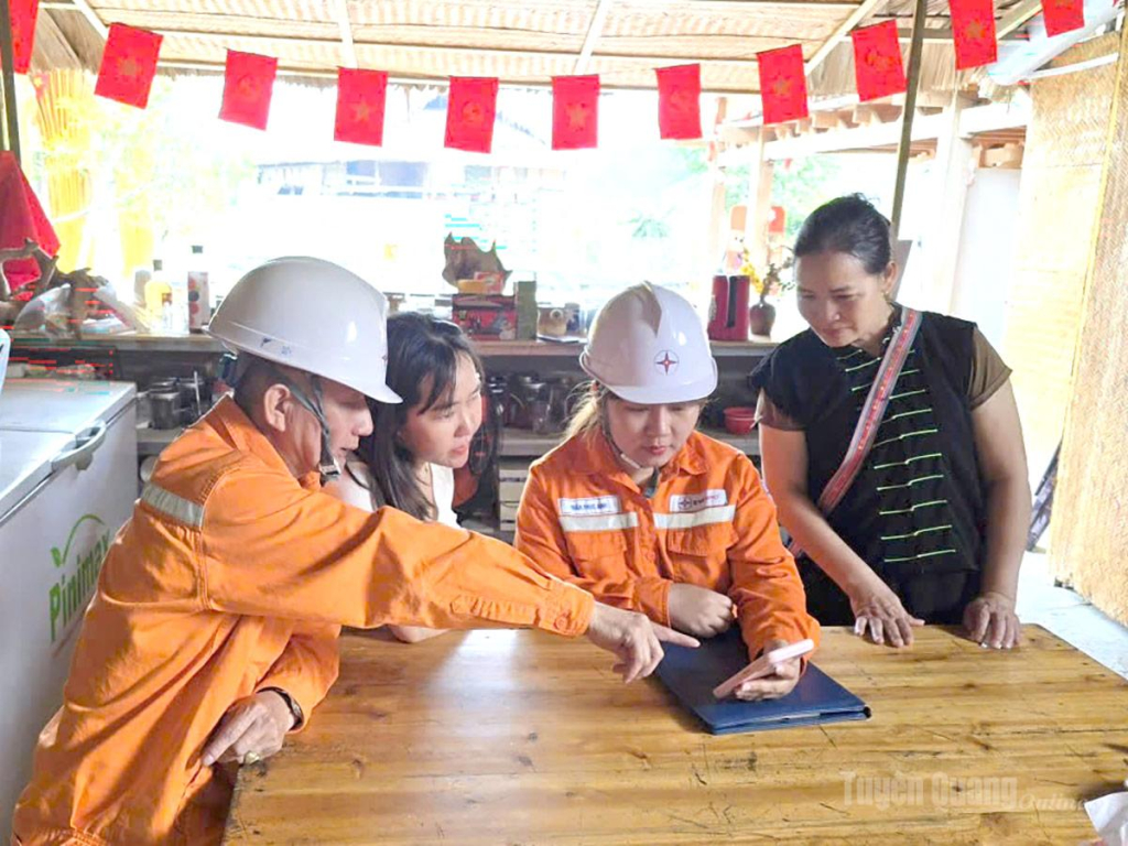 Cán bộ nhân viên Điện lực Hà Giang hướng dẫn khách hàng sử dụng App EVNCSKH kiểm tra lượng điện sử dụng của gia đình.