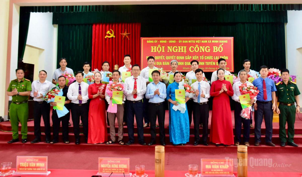 Đồng chí Nguyễn Hưng Vượng và lãnh đạo xã Minh Quang trao quyết định sắp xếp các thôn mới cho đại diện các thôn.