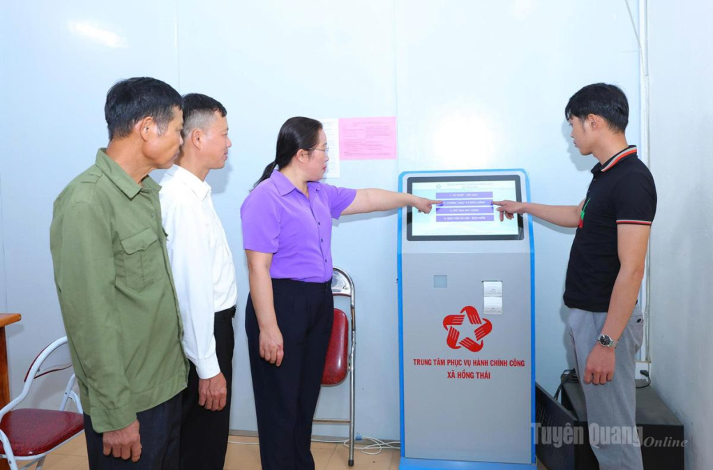 Công chức xã Hồng Thái hướng dẫn người dân lấy số thứ tự tự động khi đến giải quyết thủ tục hành chính.