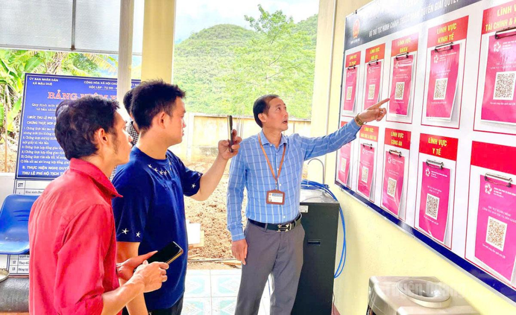 Cán bộ Trung tâm Phục vụ hành chính công xã Mậu Duệ hướng dẫn người dân quét mã QR để tra cứu và thực hiện thủ tục hành chính trực tuyến.