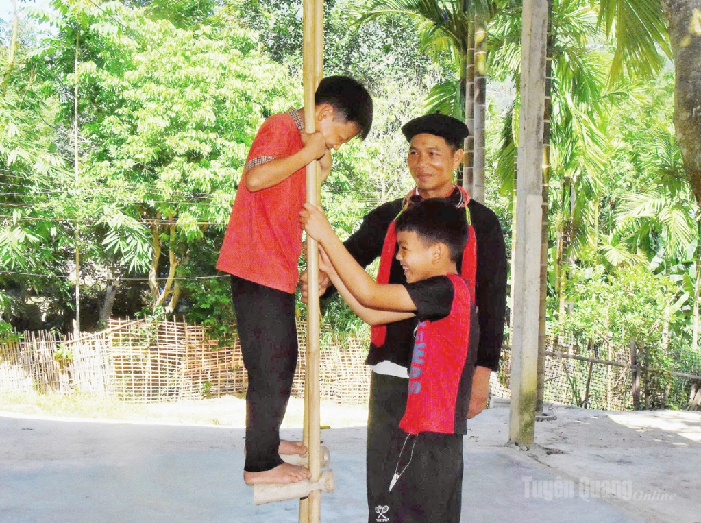 Anh Triệu Tống Giang hướng dẫn các em nhỏ trong thôn tập luyện trò chơi cà kheo truyền thống.