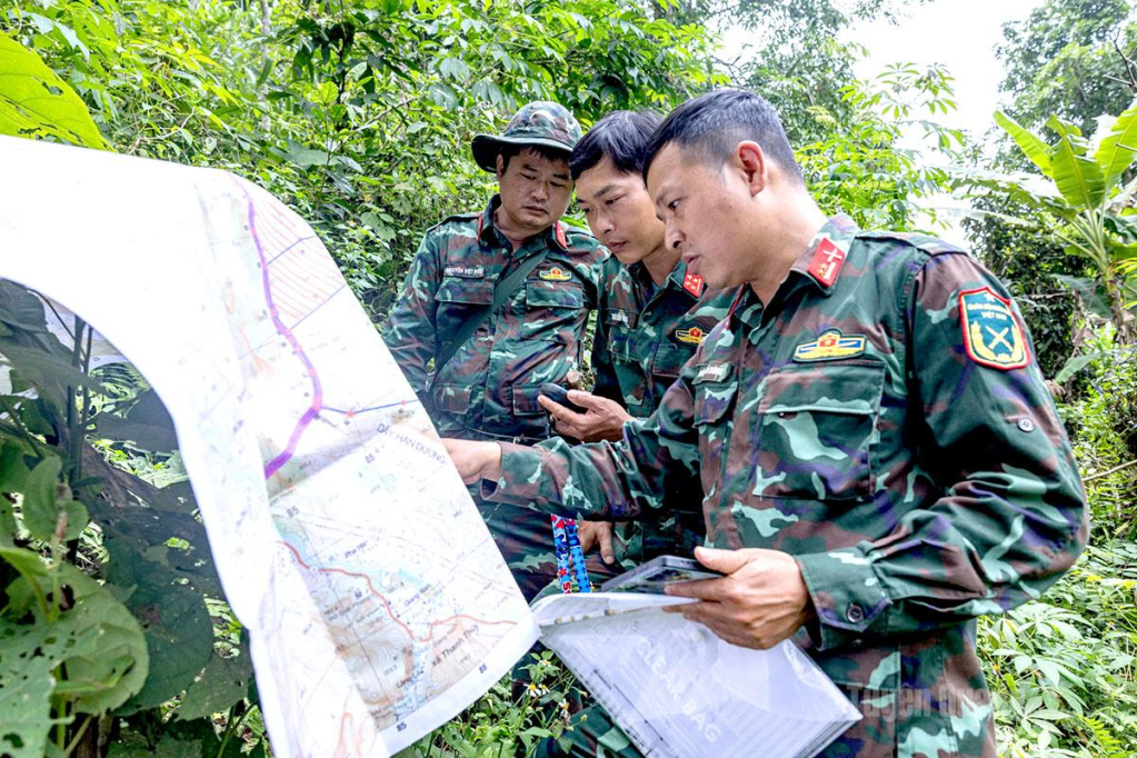 Trung tá Hoàng Vũ Dũng, Đội phó Đội tìm kiếm, quy tập hài cốt liệt sĩ cùng cán bộ đối chiếu bản đồ, xác định vị trí trước khi tổ chức khảo sát thực địa.
