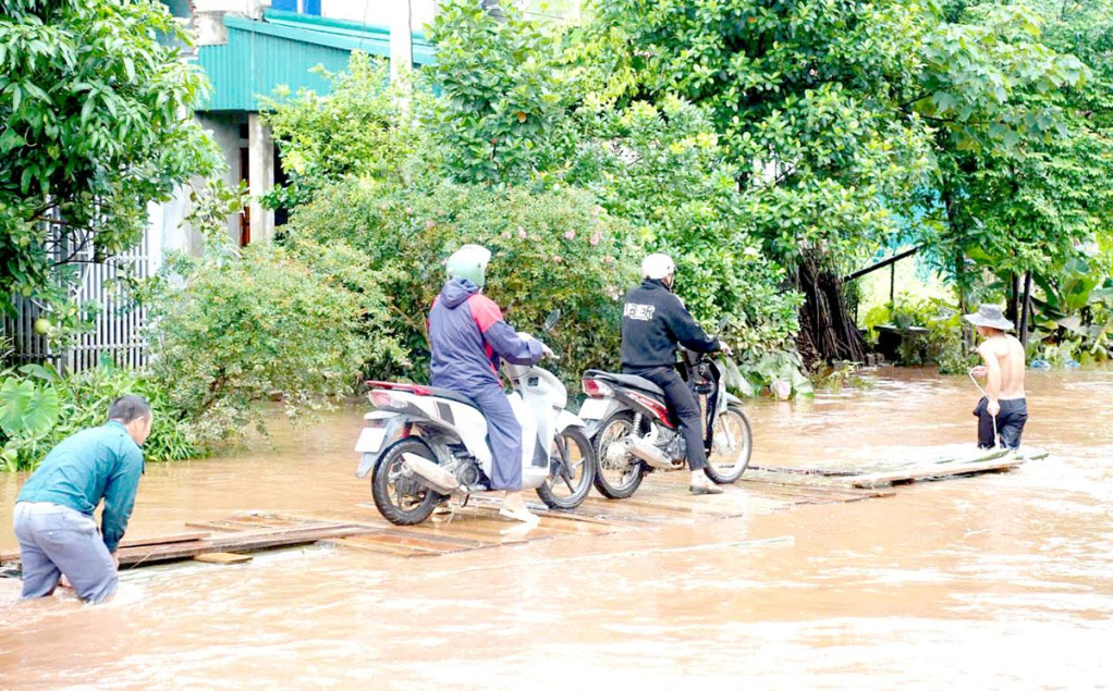 Người dân phải sử dụng bè, mảng để di chuyển trên Quốc lộ 279, đoạn qua Cụm công nghiệp Tân Bắc, xã Tân Trịnh.