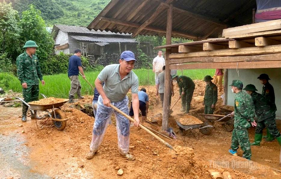 Các lực lượng giúp gia đình ông Vi Học Lần, thôn Lán Xì dọn dẹp đất đá sau sạt lở.