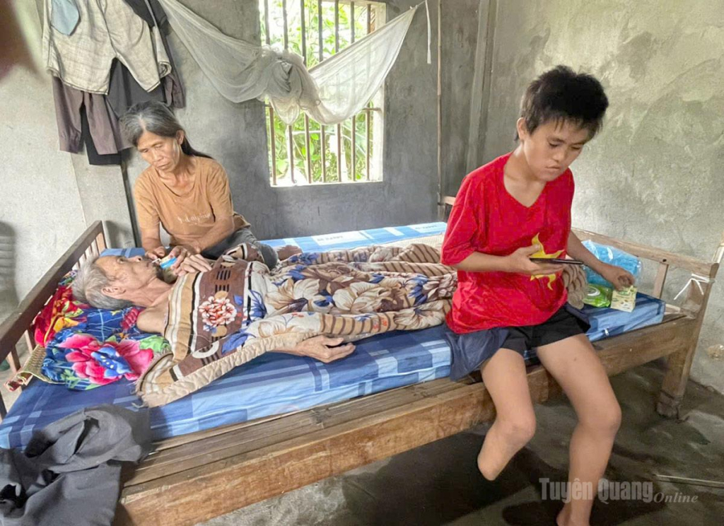 Chị Hoàng Thị Hó, thôn Thác Vệ, xã Bằng Hành, tỉnh Tuyên Quang đang chăm sóc chồng nằm liệt  và con gái khuyết tật.