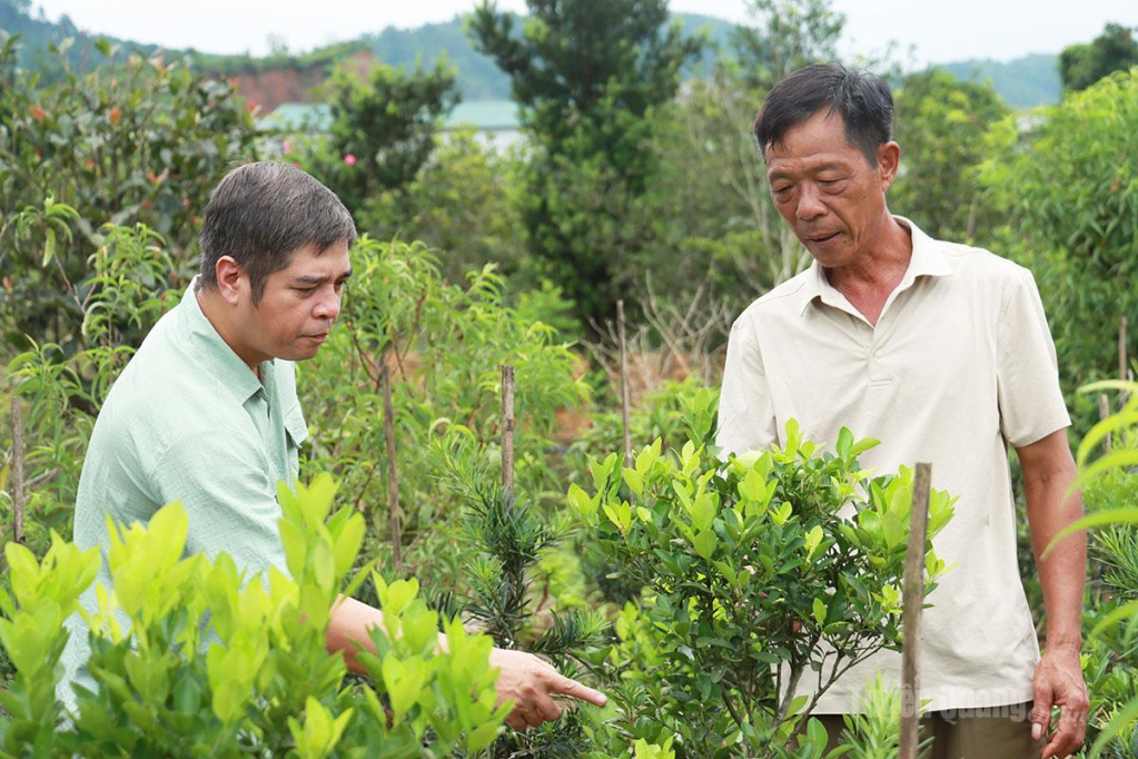 Chuyên viên Phòng Kinh tế xã Tân Quang (bên trái ảnh) thăm mô hình phát triển kinh tế của người dân.