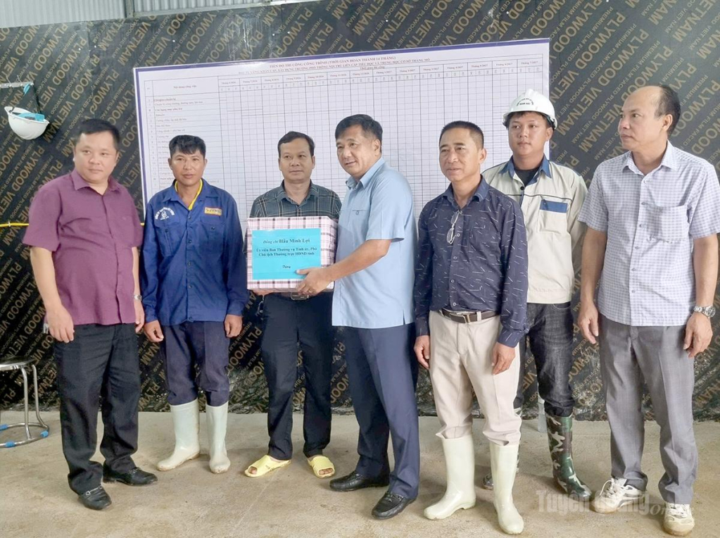 Đồng chí Phó Chủ tịch Thường trực HĐND tỉnh Hầu Minh Lợi trao quà động viên cán bộ, kỹ sư và công nhân đang thi công trên công trường.
