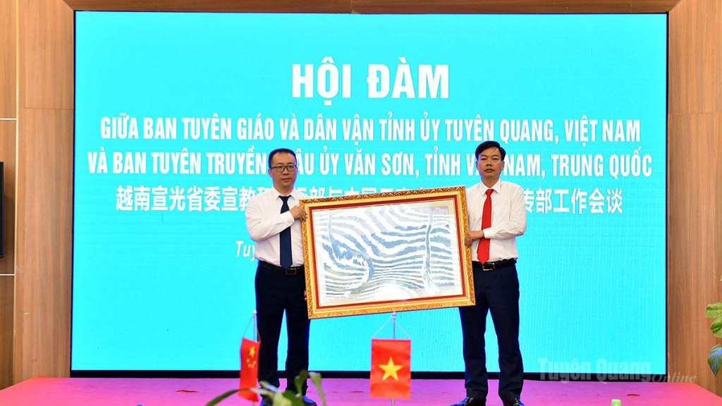 Đồng chí Nguyễn Lam Sơn, Phó Trưởng ban Thường trực Ban Tuyên giáo và Dân vận Tỉnh ủy tặng Đoàn công tác Châu ủy Văn Sơn bức tranh phong cảnh Tuyên Quang.