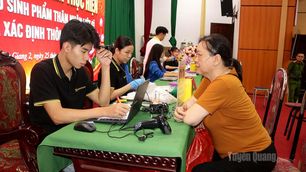 Cán bộ chuyên môn hướng dẫn, đối chiếu thông tin và thu nhận mẫu sinh phẩm ADN của thân nhân liệt sĩ tại điểm thu nhận ở phường Hà Giang 2.