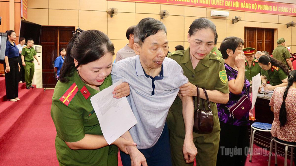 Lực lượng Công an hỗ trợ thân nhân liệt sĩ cao tuổi trong quá trình thực hiện thu nhận mẫu sinh phẩm ADN.