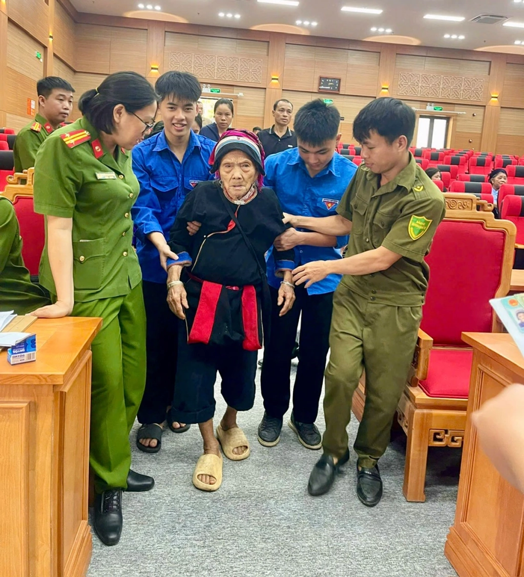Lực lượng chức năng hỗ trợ bà Tráng Thị Pẩy, sinh năm 1930, mẹ liệt sĩ, thôn Nà Nèn, xã Bắc Mê trong quá trình đến lấy mẫu sinh phẩm.