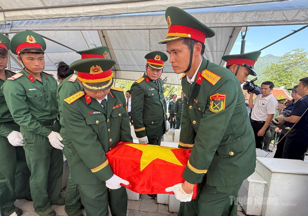 Lực lượng vũ trang di chuyển hài cốt liệt sĩ về nơi an táng.