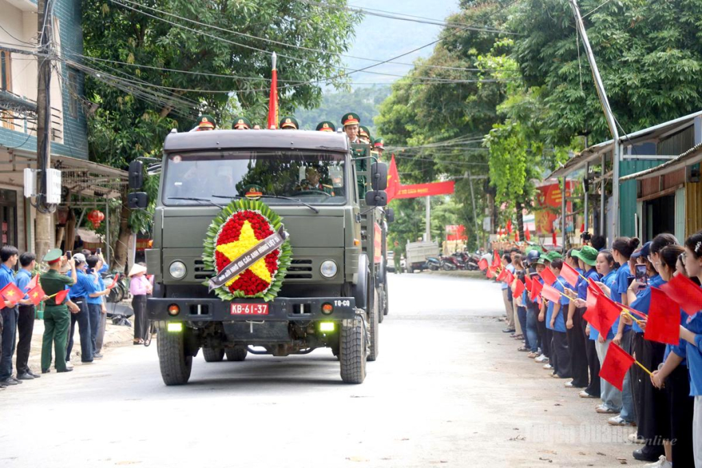 Người dân chờ đón đoàn xe di chuyển hài cốt liệt sĩ từ Nhà quàn Đội tìm kiếm, quy tập hài cốt liệt sĩ, thôn Giang Nam, xã Thanh Thủy về Nghĩa trang liệt sĩ Quốc gia Vị Xuyên.