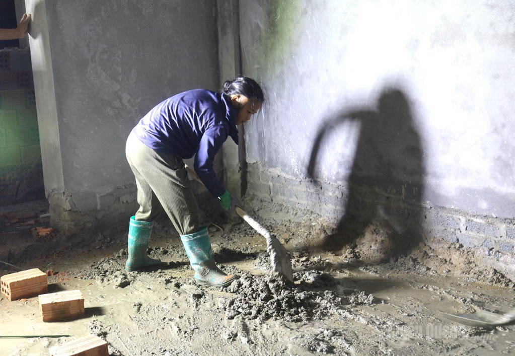 Dưới ánh đèn điện, những giọt mồ hôi thấm đẫm vạt áo, hình bóng người công nhân in hằn trên những bức tường, lặng lẽ vun đắp từng mét nền, góp phần đưa ngôi trường vùng biên sớm thành hình.