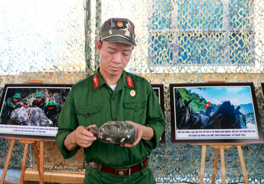 Cựu chiến binh  Nguyễn Văn Kim bên những kỷ vật được tìm thấy  trong quá trình tìm kiếm,   quy tập hài cốt liệt sĩ.