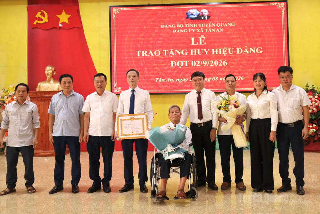 Các đại biểu tặng hoa, chụp ảnh lưu niệm cùng đảng viên Ma Phúc Nhót, Chi bộ thôn Tân Minh.
