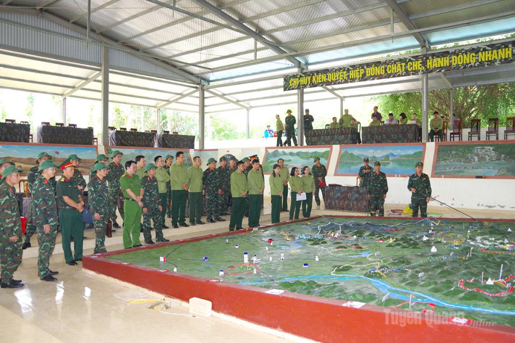 Các đại biểu theo dõi phương án chiến đấu trên sa bàn tác chiến.