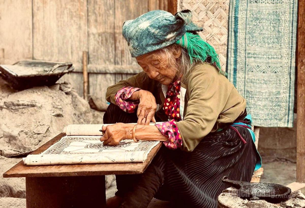  Nghệ nhân  Sùng Thị Cở, 97 tuổi,  miệt mài vẽ sáp ong trên vải lanh,  gìn giữ nghề  truyền thống.