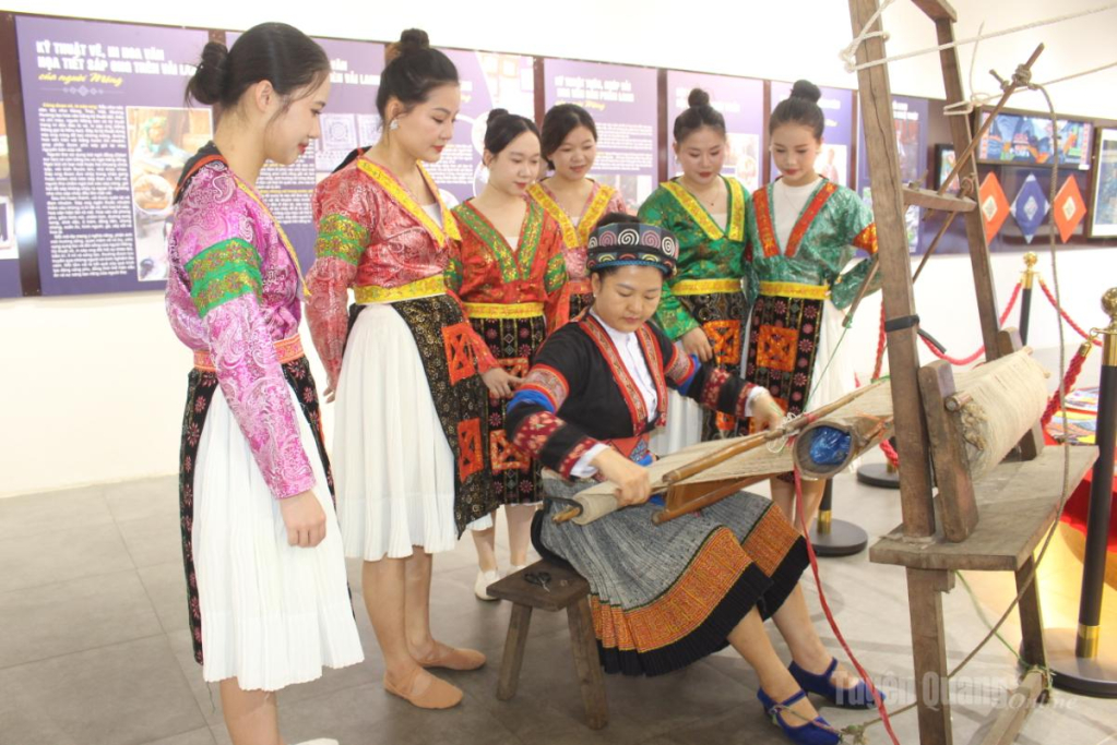 Nghệ nhân hướng dẫn du khách trải nghiệm dệt vải lanh truyền thống của đồng bào dân tộc Mông tại triển lãm “Sợi lanh kể chuyện văn hóa người Mông”.