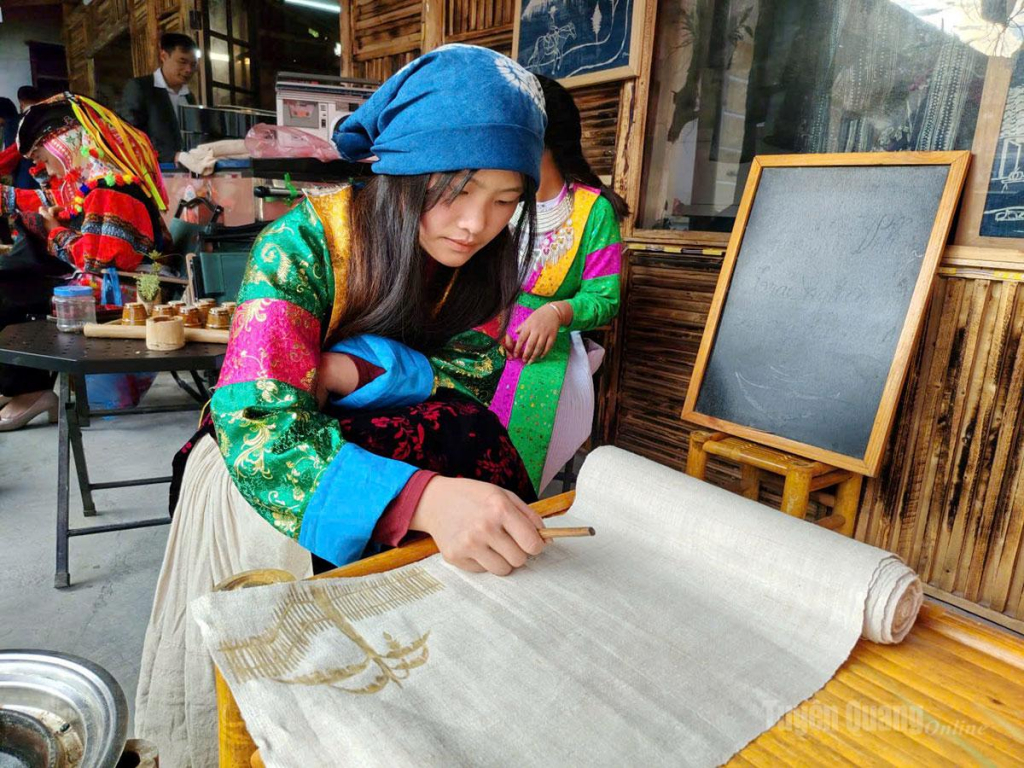 Du khách trải nghiệm vẽ sáp ong trên vải lanh tại làng nghề dệt lanh xã Lũng Cú.                                    Ảnh: Văn Long.