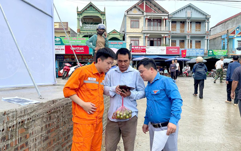 Đoàn viên thanh niên và cán bộ Điện lực Na Hang trực tiếp hướng dẫn người dân cài đặt ứng dụng EVN CSKH trên điện thoại thông minh.