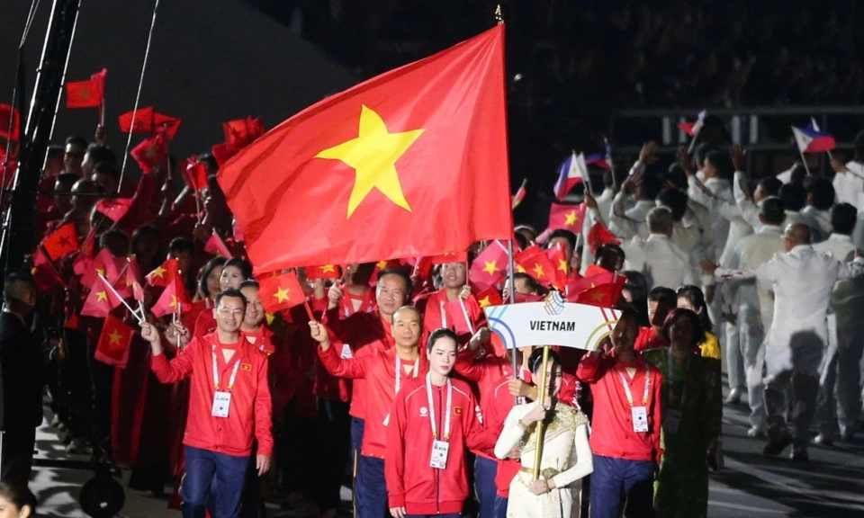 Trung vệ U23 Việt Nam v&agrave; L&ecirc; Thanh Th&uacute;y cầm cờ cho đo&agrave;n TTVN ở Asiad