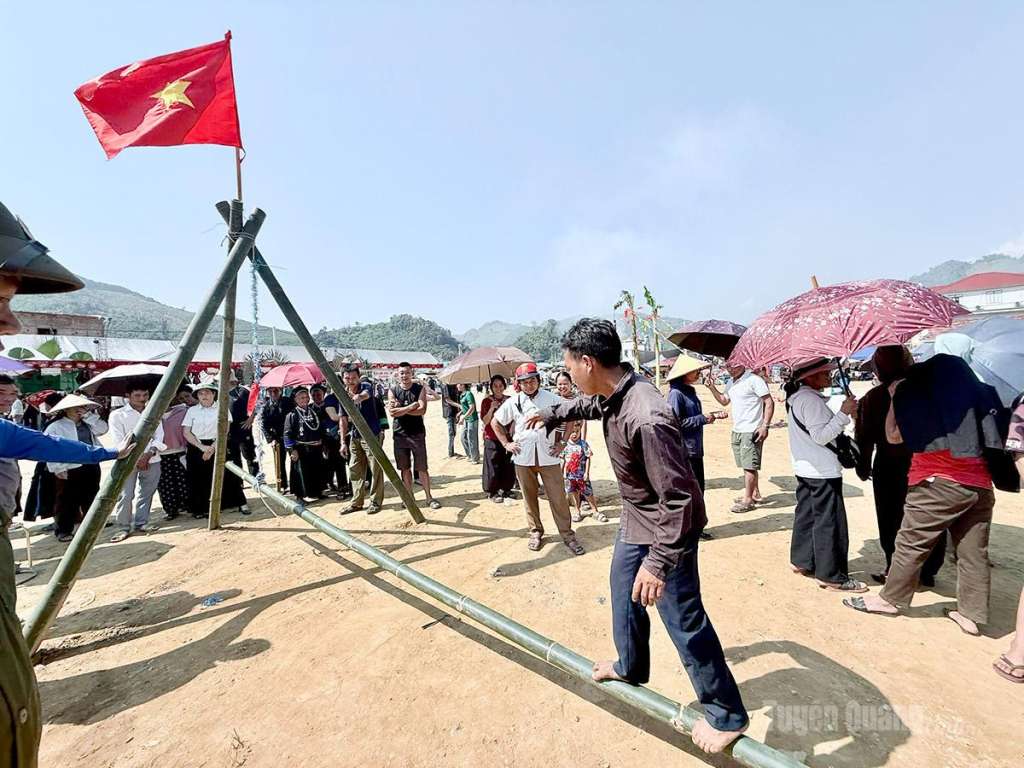 Nhân dân tham gia trò chơi dân gian đi cầu tre giữ thăng bằng.