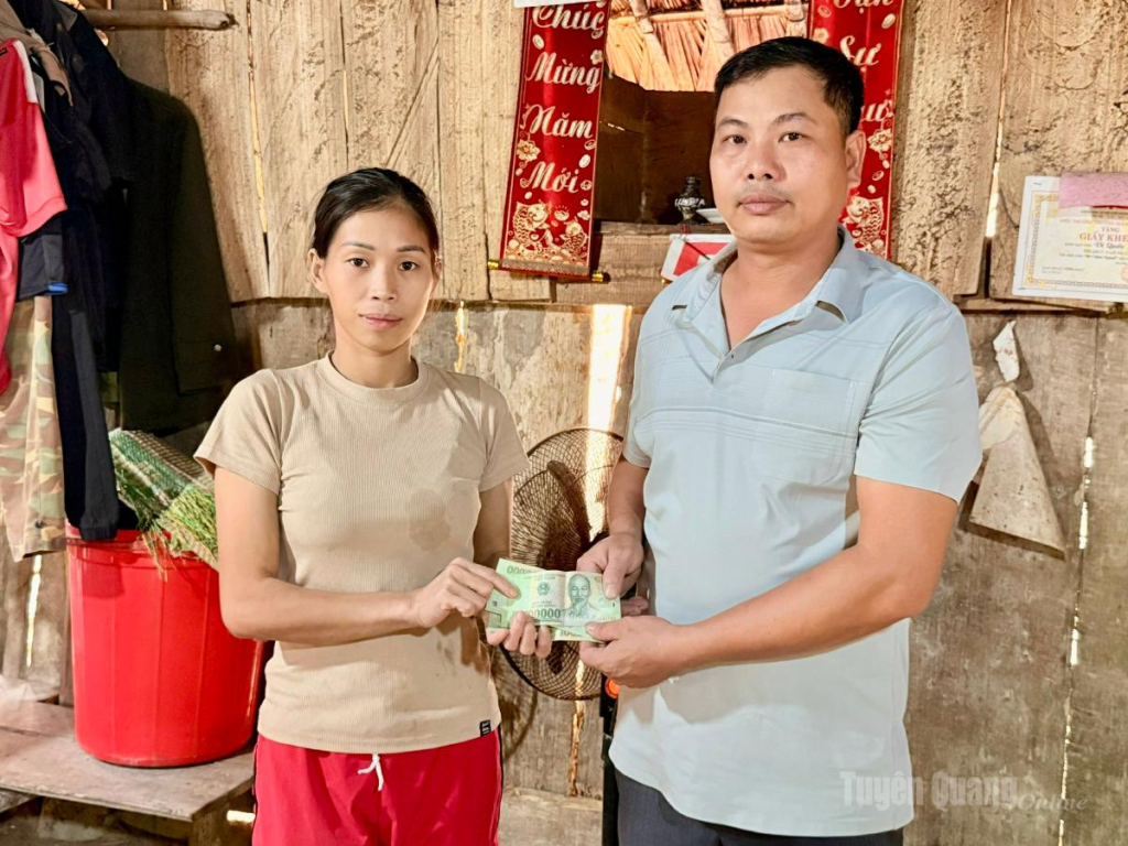 Đại diện thôn Nắc Con trao tiền hỗ trợ cho gia đình anh Vi Văn Bốn.