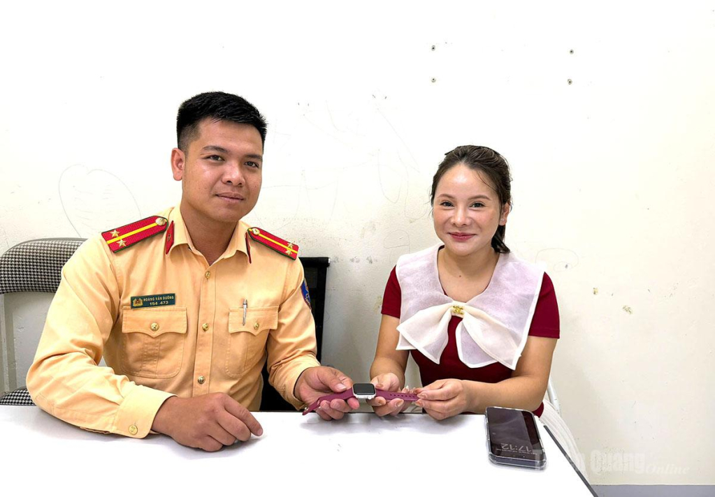 Trung úy Hoàng Văn Dưỡng trao trả đồng hồ thông minh cho chị Sùng Mỹ Hạnh.